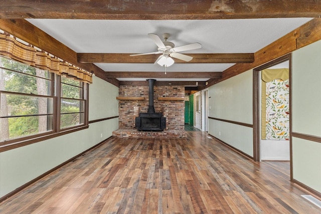 2216 Silverdale Rd, Augusta, GA 30906 - unfurnished living room with a wood stove, wood-type flooring, baseboards, and beam ceiling