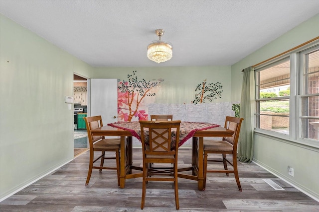 2216 Silverdale Rd, Augusta, GA 30906 - dining room with wood finished floors, a textured ceiling, baseboards, and a chandelier