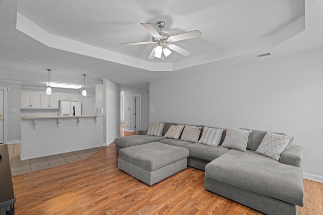 1382 Shadow Oak Dr, Evans, GA 30809 - living area featuring a tray ceiling, light wood-style floors, ceiling fan, and baseboards