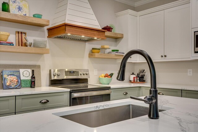 kitchen with appliances with stainless steel finishes, ornamental molding, custom exhaust hood, white cabinetry, and green cabinets