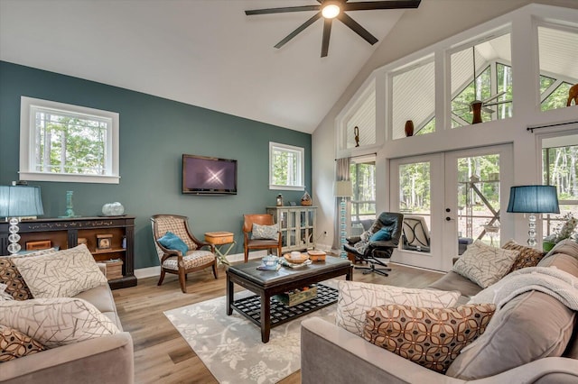 living room featuring ceiling fan, light hardwood / wood-style floors, high vaulted ceiling, and french doors