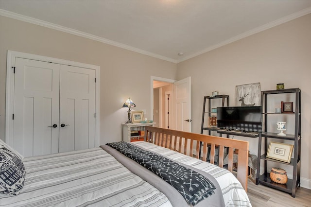 bedroom featuring a closet, light hardwood / wood-style floors, and ornamental molding