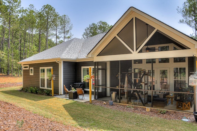 rear view of house with a lawn, a sunroom, and a patio