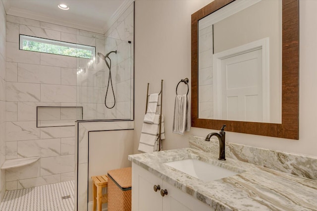 bathroom with tiled shower, vanity, and ornamental molding