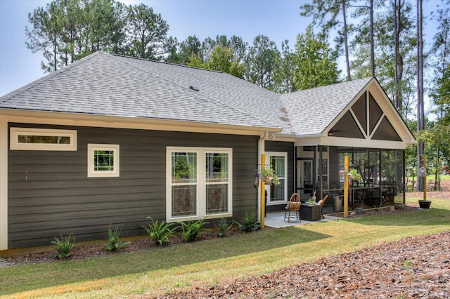 rear view of house featuring a yard, a patio area, and a sunroom