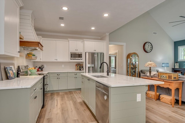 kitchen with custom exhaust hood, sink, light hardwood / wood-style flooring, an island with sink, and stainless steel appliances