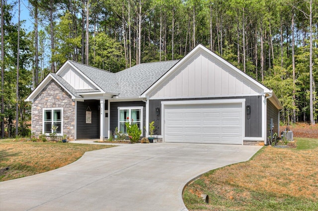 view of front of property with a front yard, central AC, and a garage