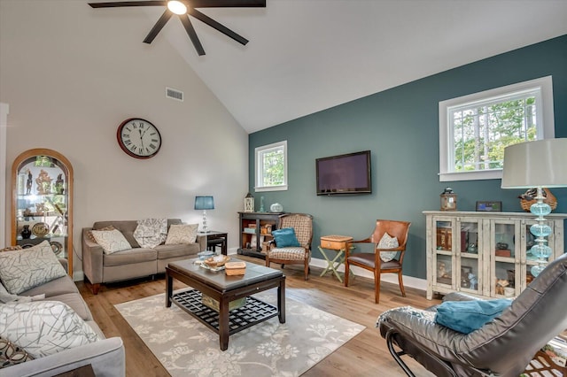 living room featuring light hardwood / wood-style floors, high vaulted ceiling, and ceiling fan