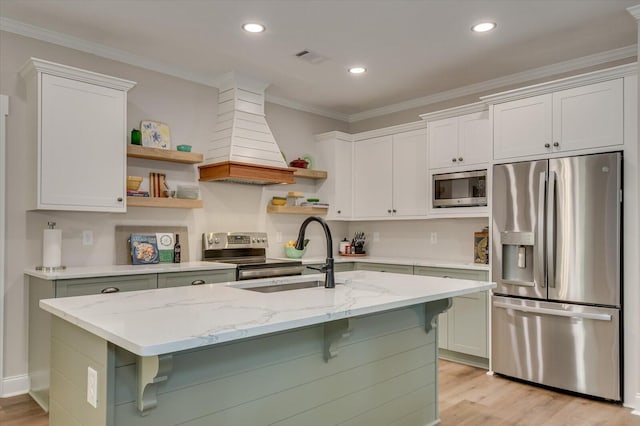 kitchen featuring light stone countertops, sink, premium range hood, white cabinets, and appliances with stainless steel finishes