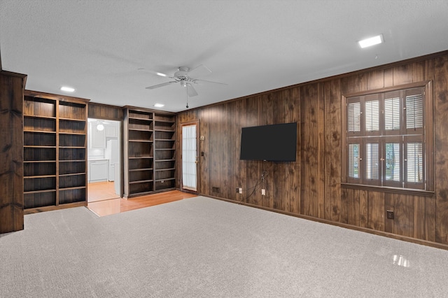 3076 Westwood Rd, Augusta, GA 30909 - unfurnished living room featuring wood walls, ceiling fan, and carpet