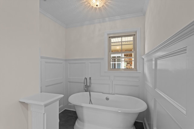3076 Westwood Rd, Augusta, GA 30909 - bathroom featuring a decorative wall, a soaking tub, wainscoting, ornamental molding, and a textured ceiling