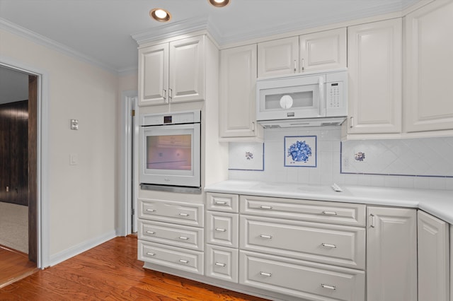 3076 Westwood Rd, Augusta, GA 30909 - kitchen featuring white appliances, ornamental molding, light wood-style flooring, light countertops, and white cabinets