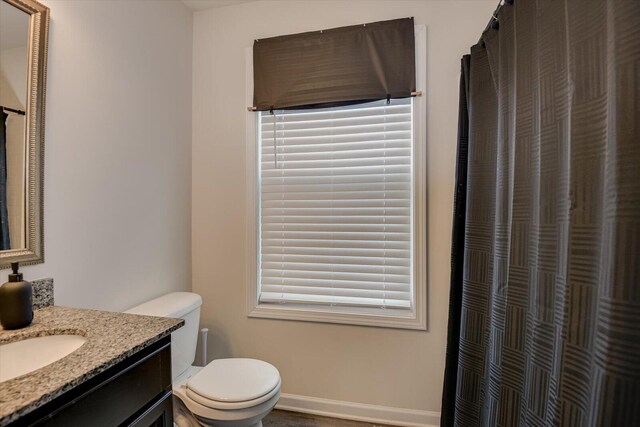 bathroom with vanity, curtained shower, and toilet