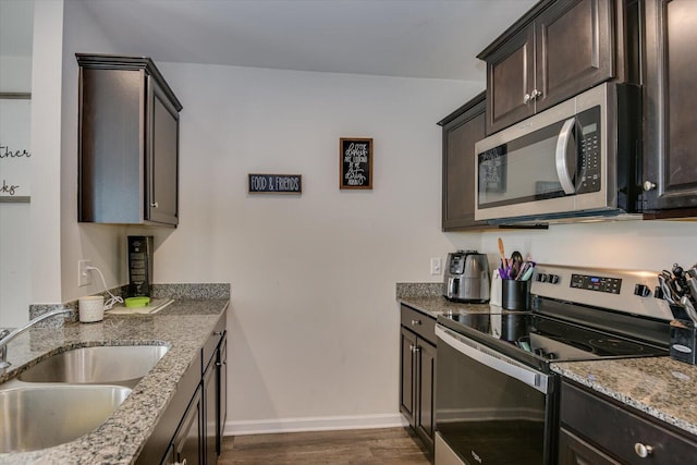 kitchen featuring light stone countertops, sink, stainless steel appliances, and dark hardwood / wood-style floors