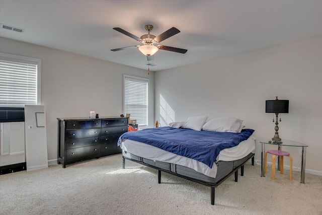 bedroom featuring multiple windows, ceiling fan, and light colored carpet