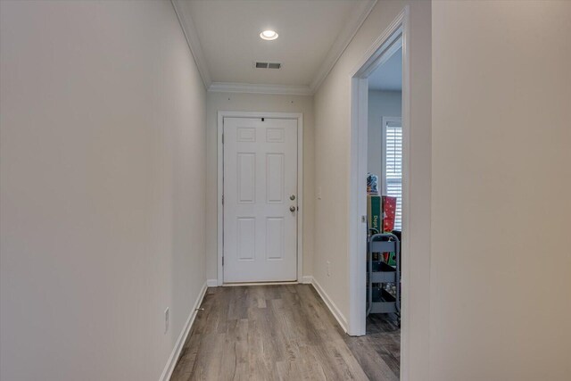 hallway with light hardwood / wood-style floors and crown molding