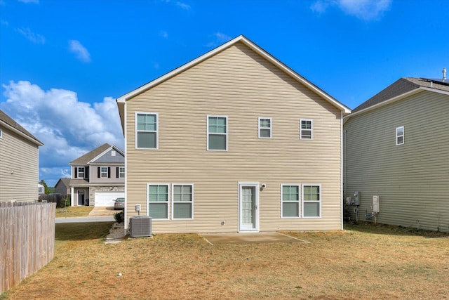 rear view of house with central air condition unit and a yard