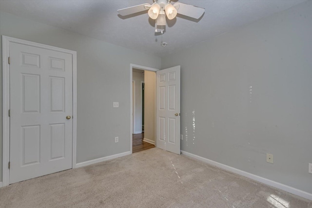 unfurnished bedroom featuring ceiling fan and light carpet