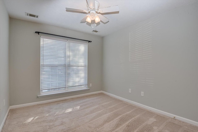 empty room featuring ceiling fan and light colored carpet