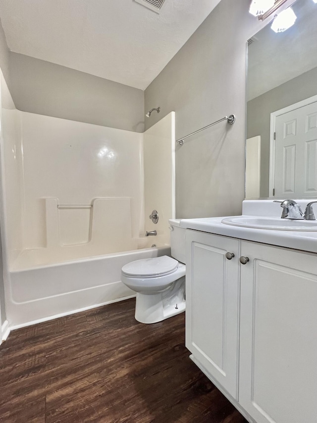 full bathroom featuring hardwood / wood-style flooring, vanity, toilet, and shower / bathing tub combination