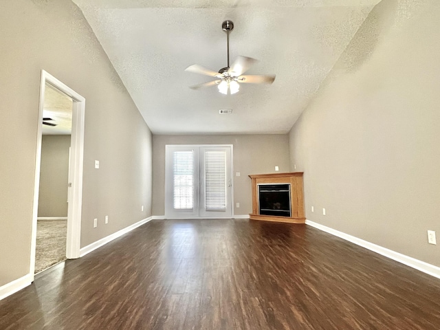 unfurnished living room with ceiling fan, a textured ceiling, and dark wood-type flooring