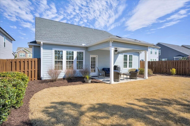 rear view of house featuring roof with shingles, a yard, a patio area, ceiling fan, and fence