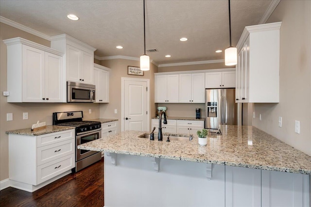 kitchen with a peninsula, a sink, appliances with stainless steel finishes, light stone countertops, and dark wood-style floors