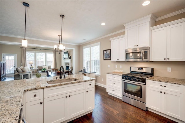 kitchen with dark wood-style flooring, crown molding, stainless steel appliances, white cabinets, and a sink