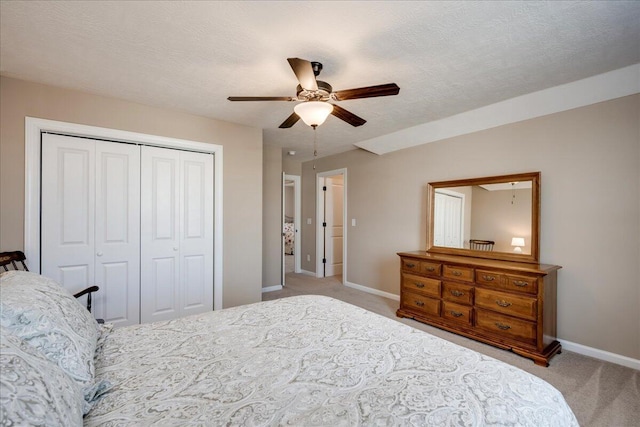 bedroom featuring baseboards, a ceiling fan, a textured ceiling, carpet flooring, and a closet