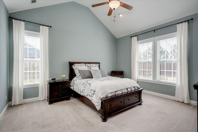 bedroom with lofted ceiling, multiple windows, baseboards, and light colored carpet