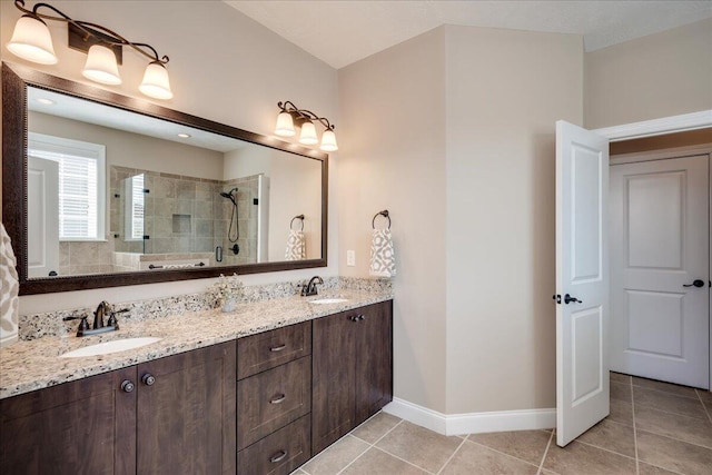 full bath with a sink, a tile shower, and tile patterned floors