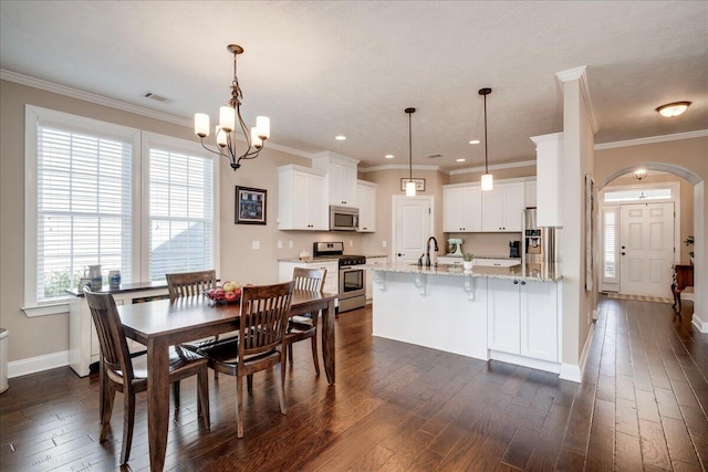 dining area with arched walkways, crown molding, visible vents, dark wood-type flooring, and baseboards