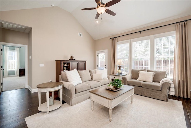 living room featuring dark wood-type flooring, plenty of natural light, high vaulted ceiling, and ceiling fan