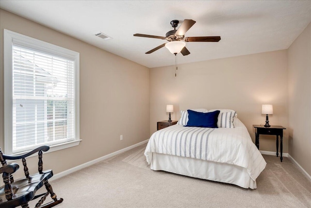 bedroom featuring a ceiling fan, light colored carpet, visible vents, and baseboards