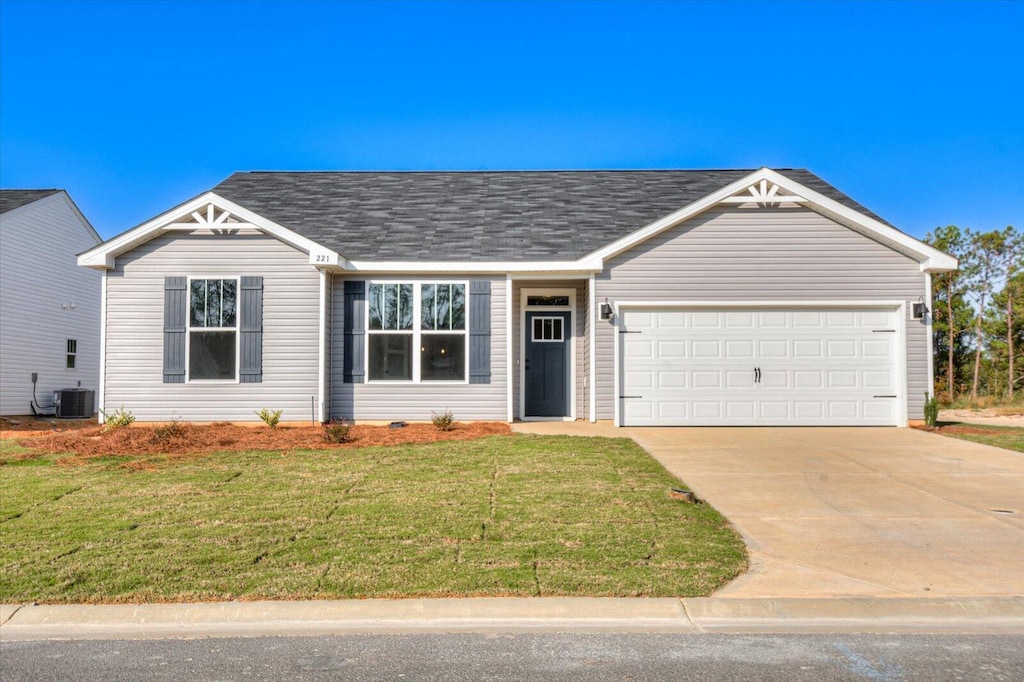 ranch-style house with a garage, central air condition unit, and a front lawn