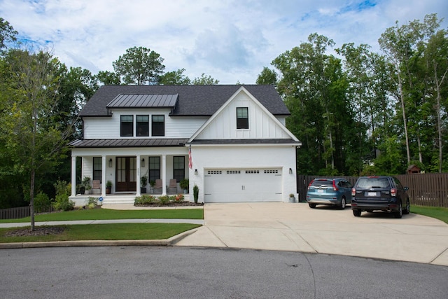 modern inspired farmhouse with a porch, a garage, and a front lawn