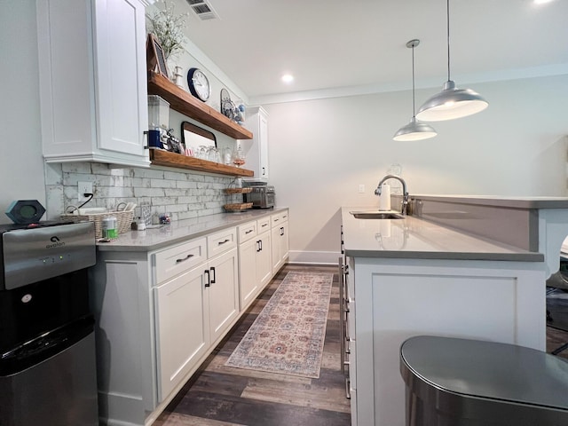 kitchen with white cabinetry, sink, decorative backsplash, and pendant lighting