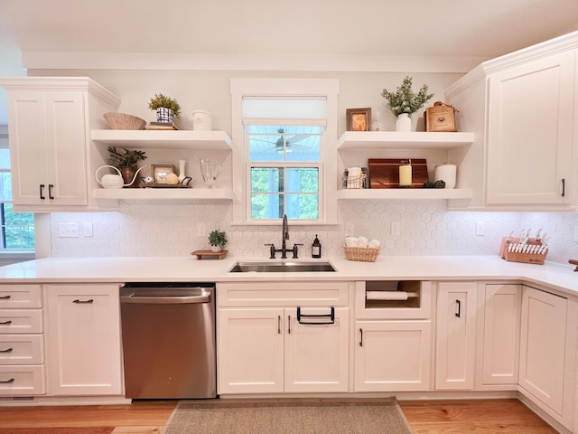 kitchen featuring sink, decorative backsplash, stainless steel dishwasher, and white cabinets