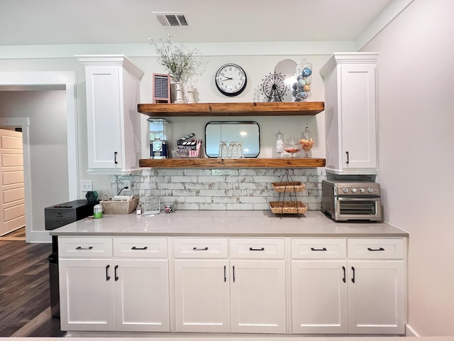 bar with white cabinetry, backsplash, and dark wood-type flooring