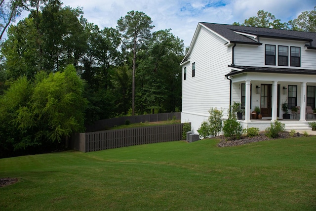 view of property exterior with a porch, a yard, and central air condition unit