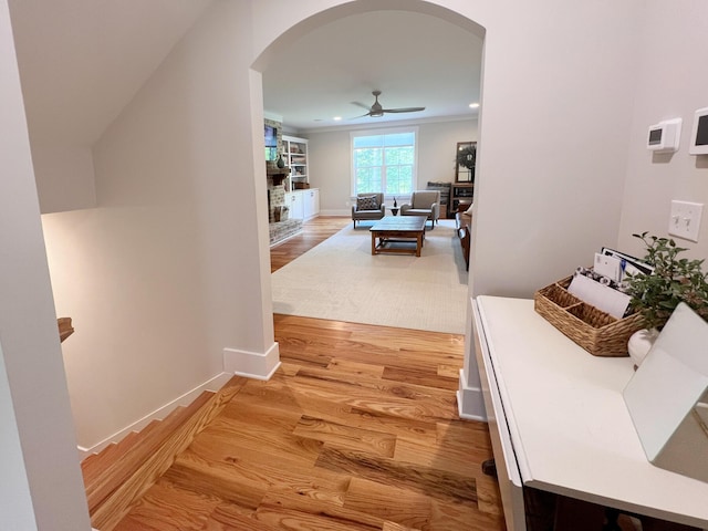 hall with wood-type flooring and ornamental molding