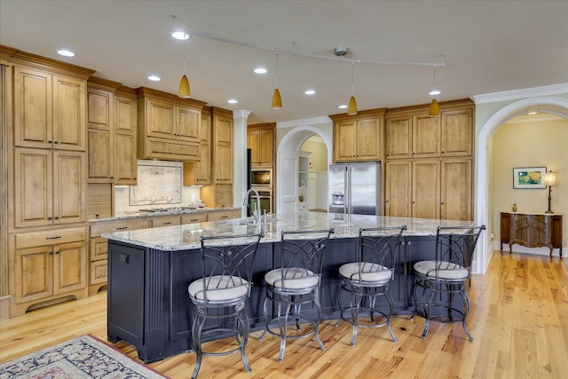 kitchen featuring light stone countertops, stainless steel appliances, tasteful backsplash, a large island, and a breakfast bar