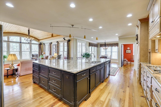 kitchen featuring a spacious island, decorative light fixtures, an inviting chandelier, sink, and crown molding