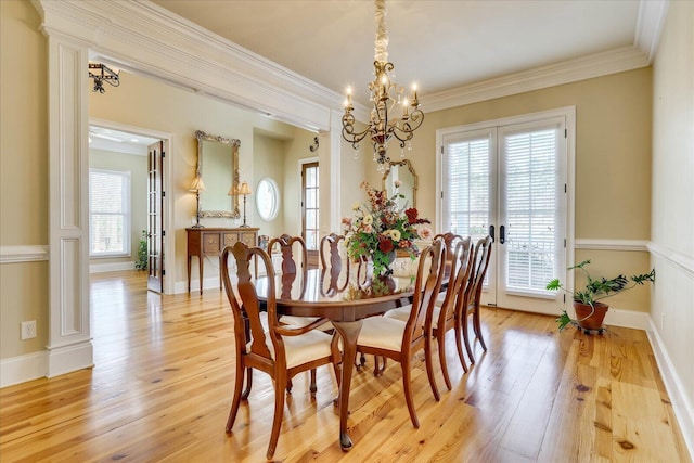 dining room with a chandelier, french doors, ornamental molding, and light hardwood / wood-style floors