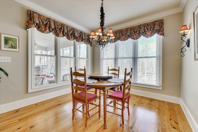 dining area with wood-type flooring, a chandelier, and ornamental molding