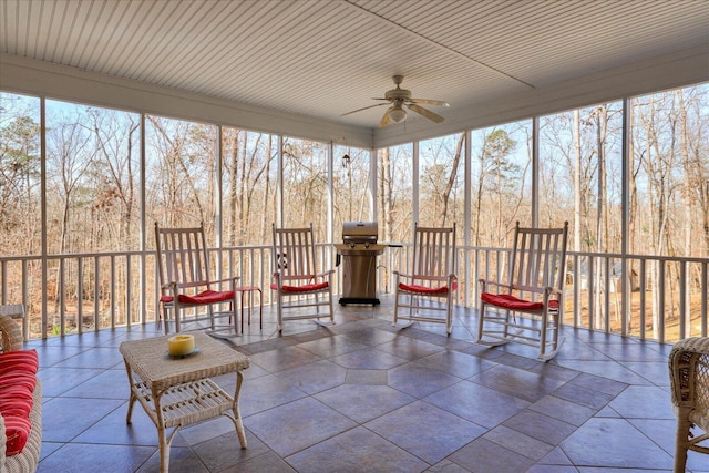 unfurnished sunroom featuring ceiling fan and a healthy amount of sunlight