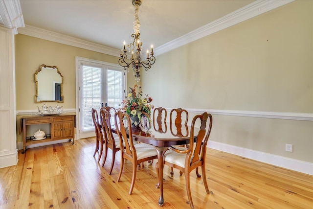 dining room with a chandelier, crown molding, and light hardwood / wood-style floors