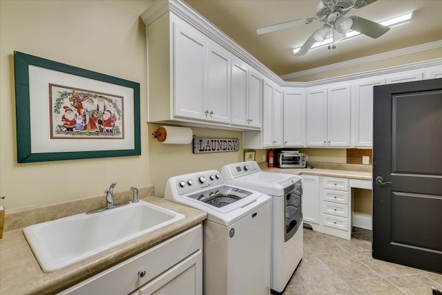 laundry room featuring washing machine and clothes dryer, ceiling fan, cabinets, crown molding, and sink