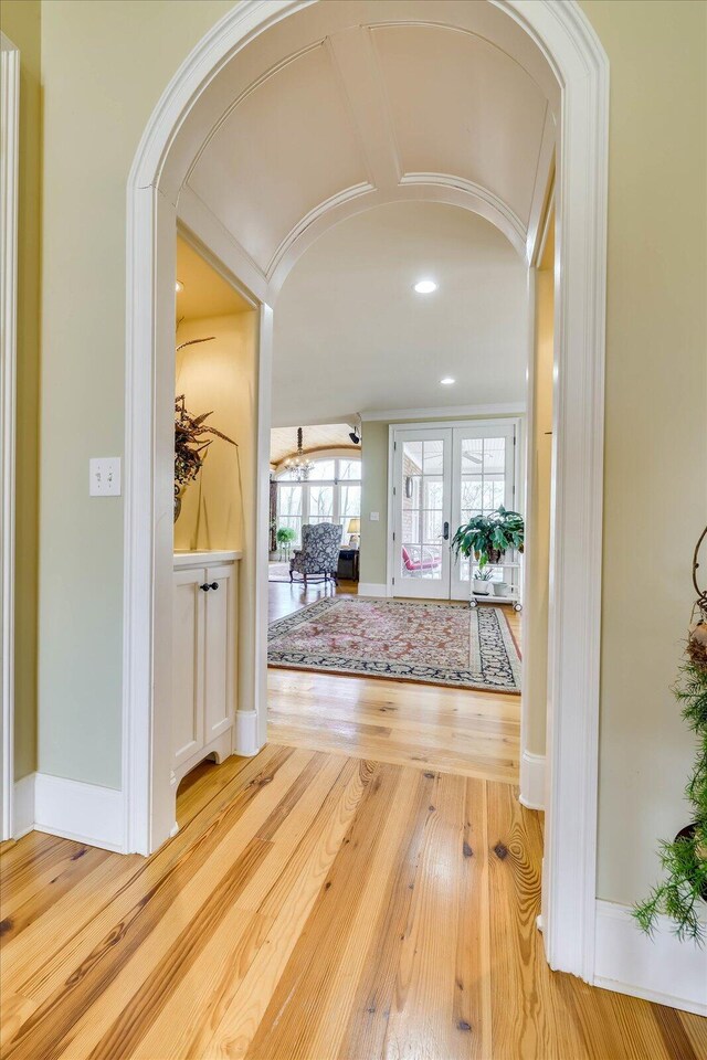 hallway with hardwood / wood-style floors and french doors