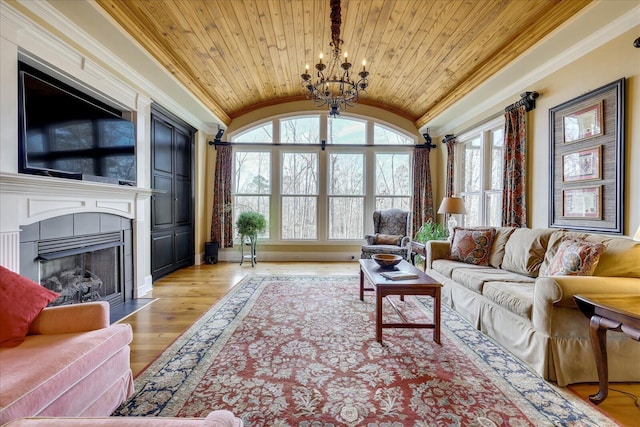 living room with a tiled fireplace, a chandelier, lofted ceiling, and wood ceiling